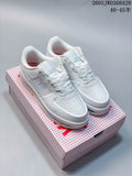 Pair of white Nike low-top sneakers displayed on a patterned box