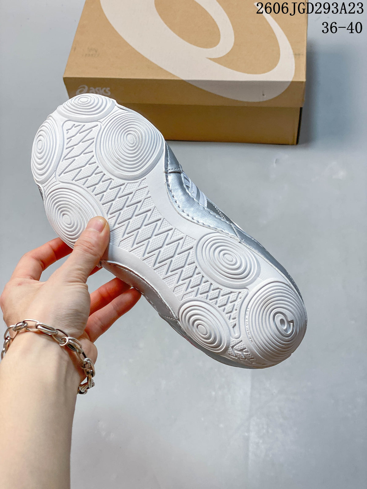 Close view of the white patterned outsole on a pink and silver sneaker.