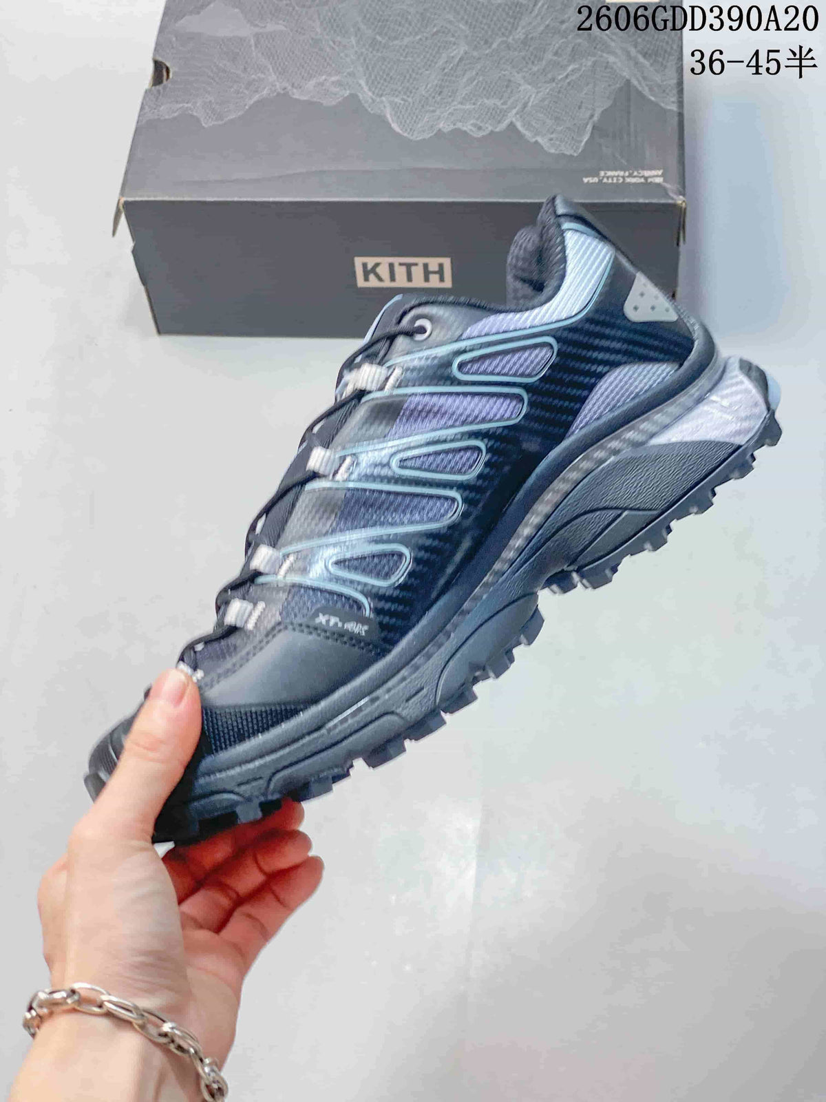 Side view of a dark blue-gray Salomon XT-4K shoe with patterned overlays and trail-style outsole.
