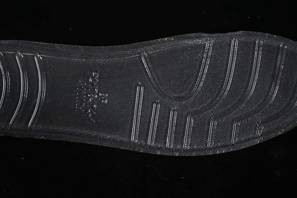 Close-up of the black sneaker outsole with textured tread.