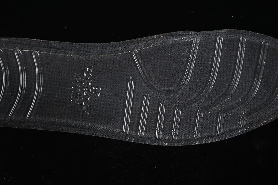 Close-up of the black sneaker outsole with textured tread.