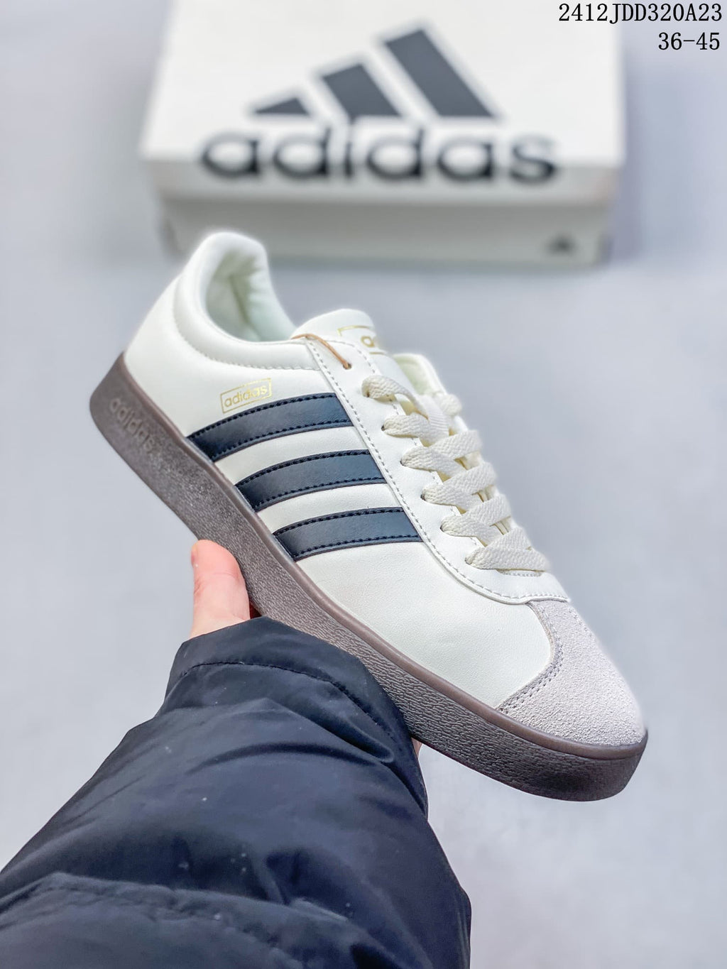 Angled side view of the white sneaker with navy stripes and light-colored toe detailing