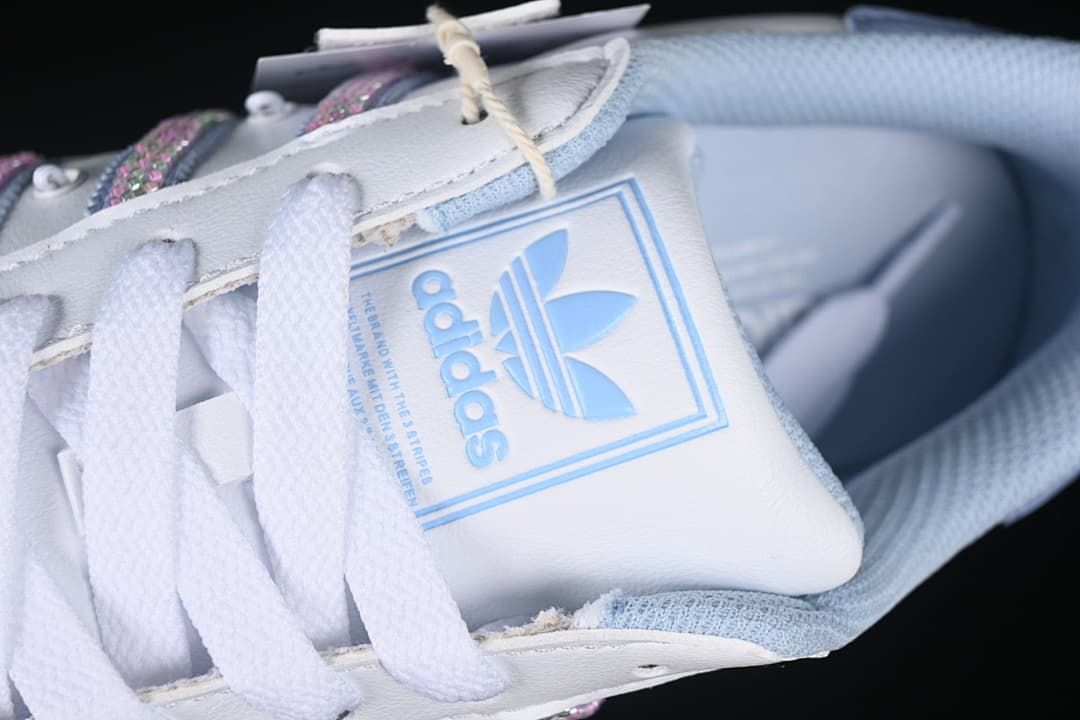 Close-up of the tongue branding, white laces, and light blue lining
