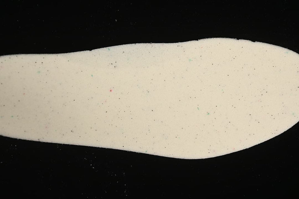 Light-colored removable shoe insert shown against a black background.