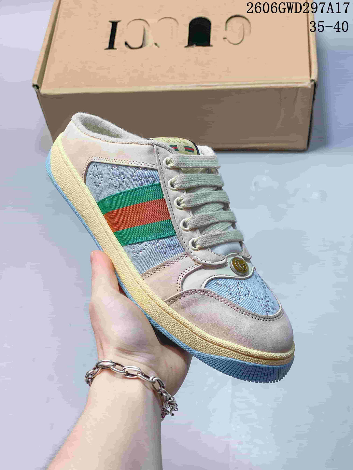 Angled view of a beige and light blue sneaker with green and red side stripes