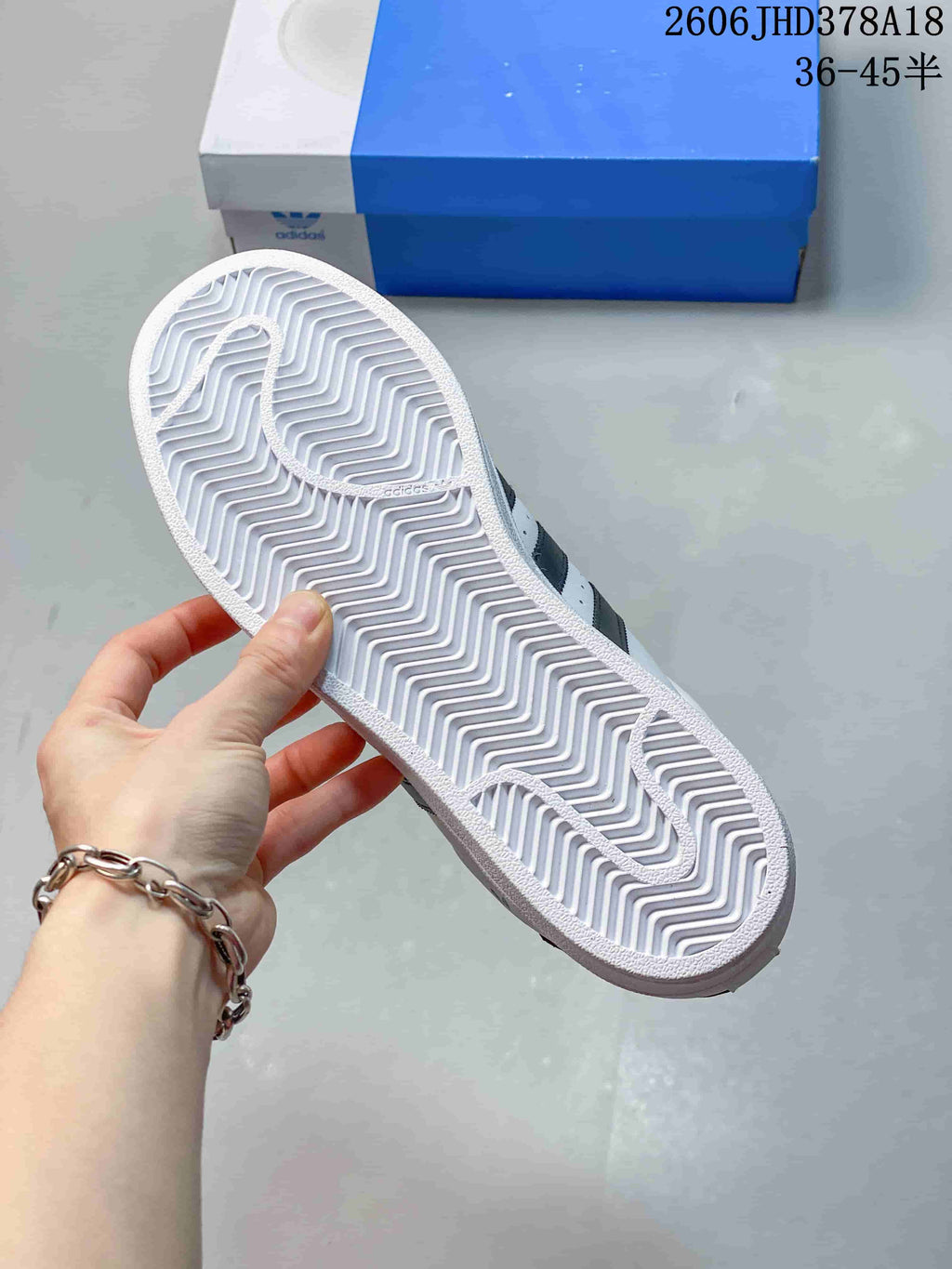 Close-up of the patterned outsole on a white Adidas Originals Superstar sneaker.
