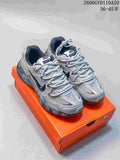 Pair of silver and gray Nike Initiator low-top sneakers with dark accents, shown on an orange shoe box.