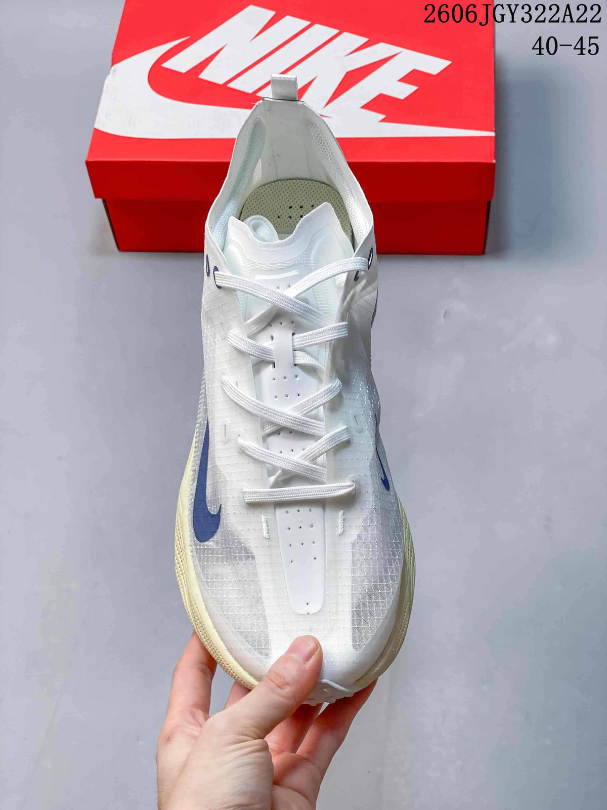 Top view of a white Nike Ava X shoe with blue accents and lace-up closure.