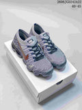 Pair of gray multicolor Nike VaporMax Flyknit sneakers with dark laces and copper-tone side Swooshes