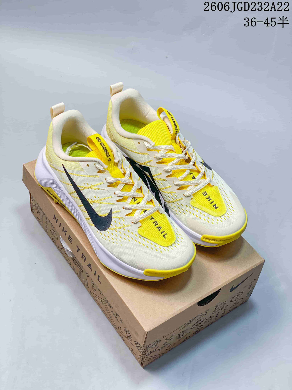 Pair of off-white and yellow Nike Wildhorse 10 trail shoes on a Nike Trail box