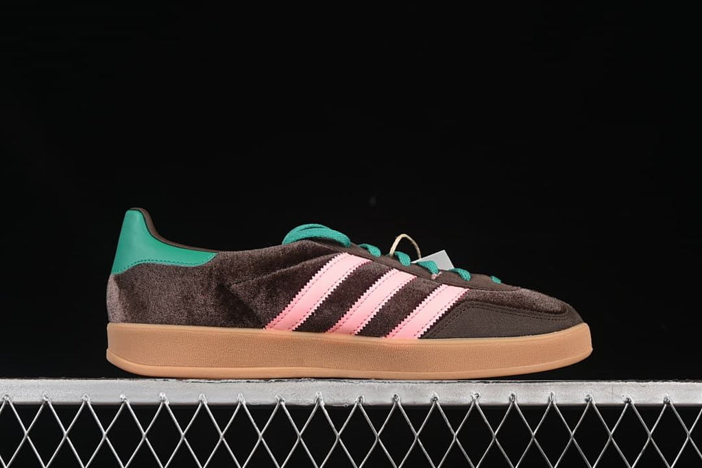 Side profile of the sneaker with pink stripes, teal heel detail, and gum-colored sole.