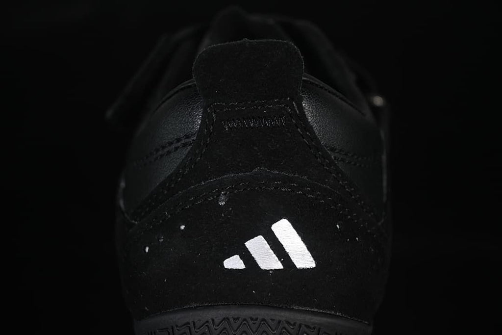 Rear view of the black sneaker with a white logo mark
