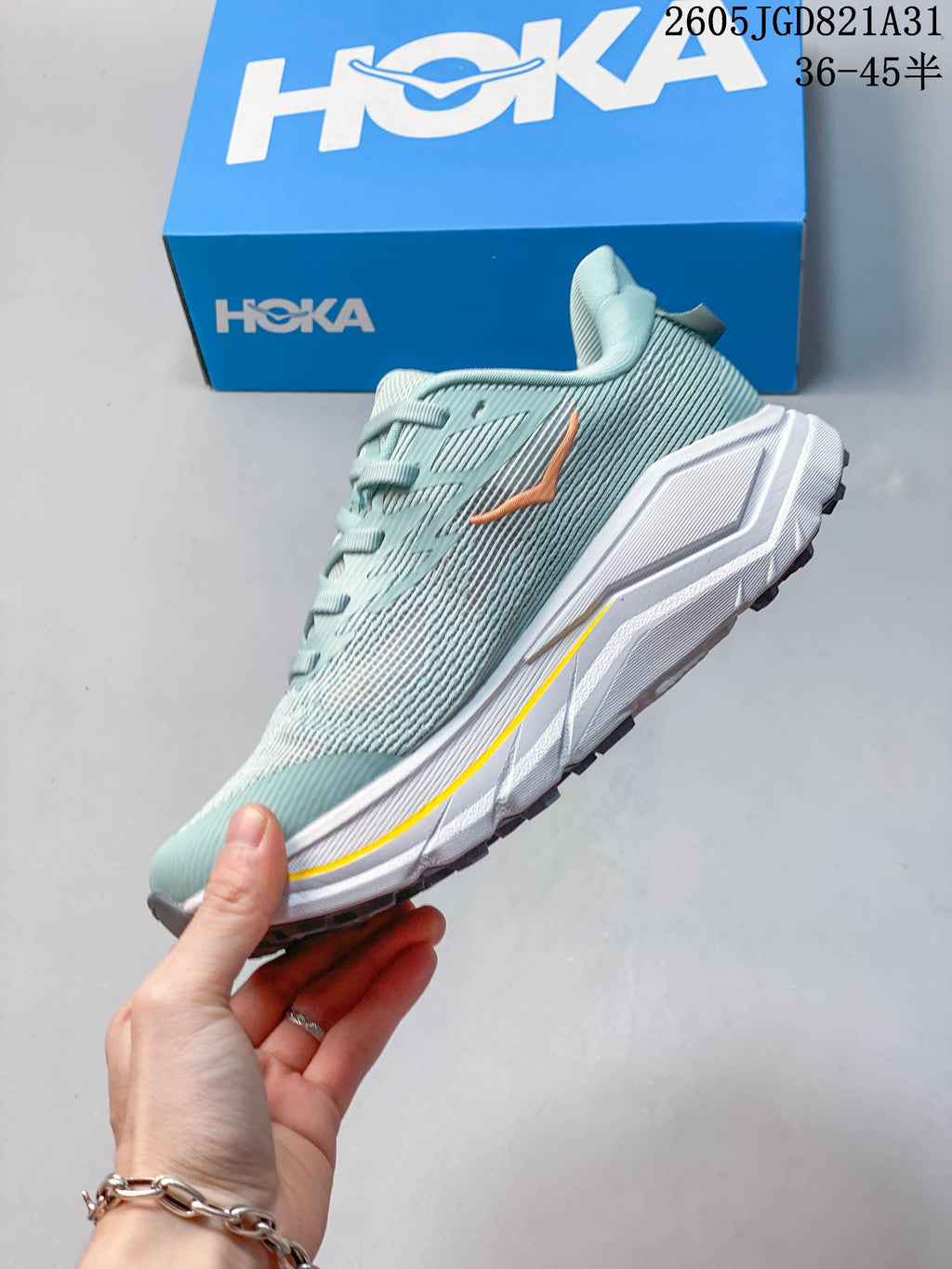Side view of a light blue HOKA Challenger 8 running shoe with peach accents