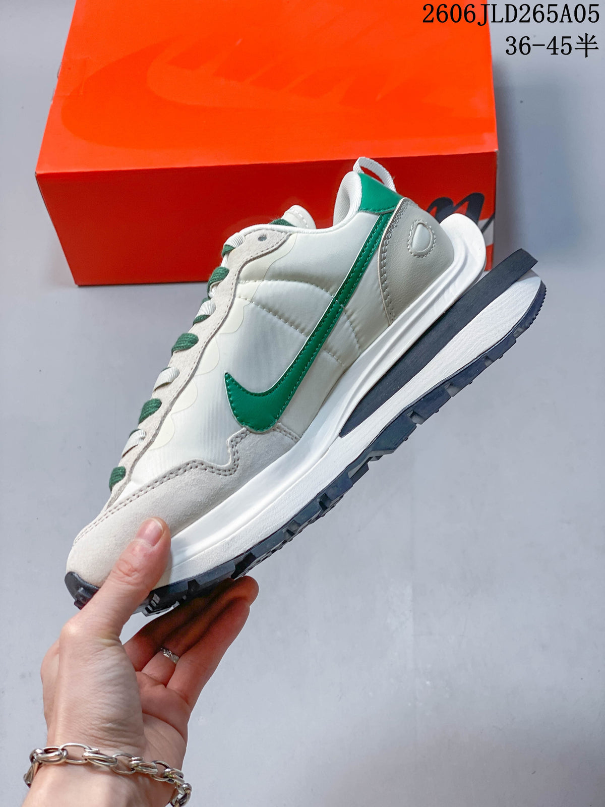 Side view showing the green Swoosh and layered sole of the off-white Nike x sacai LDWaffle.