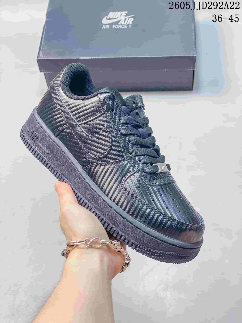 Dark patterned low-top sneaker with layered side panels and a dark sole.