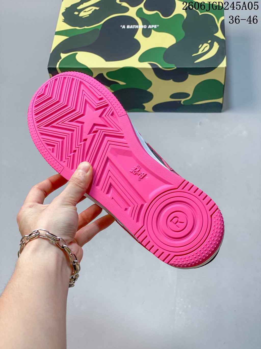 Bright pink outsole with star-shaped tread and a camouflage-patterned shoe box