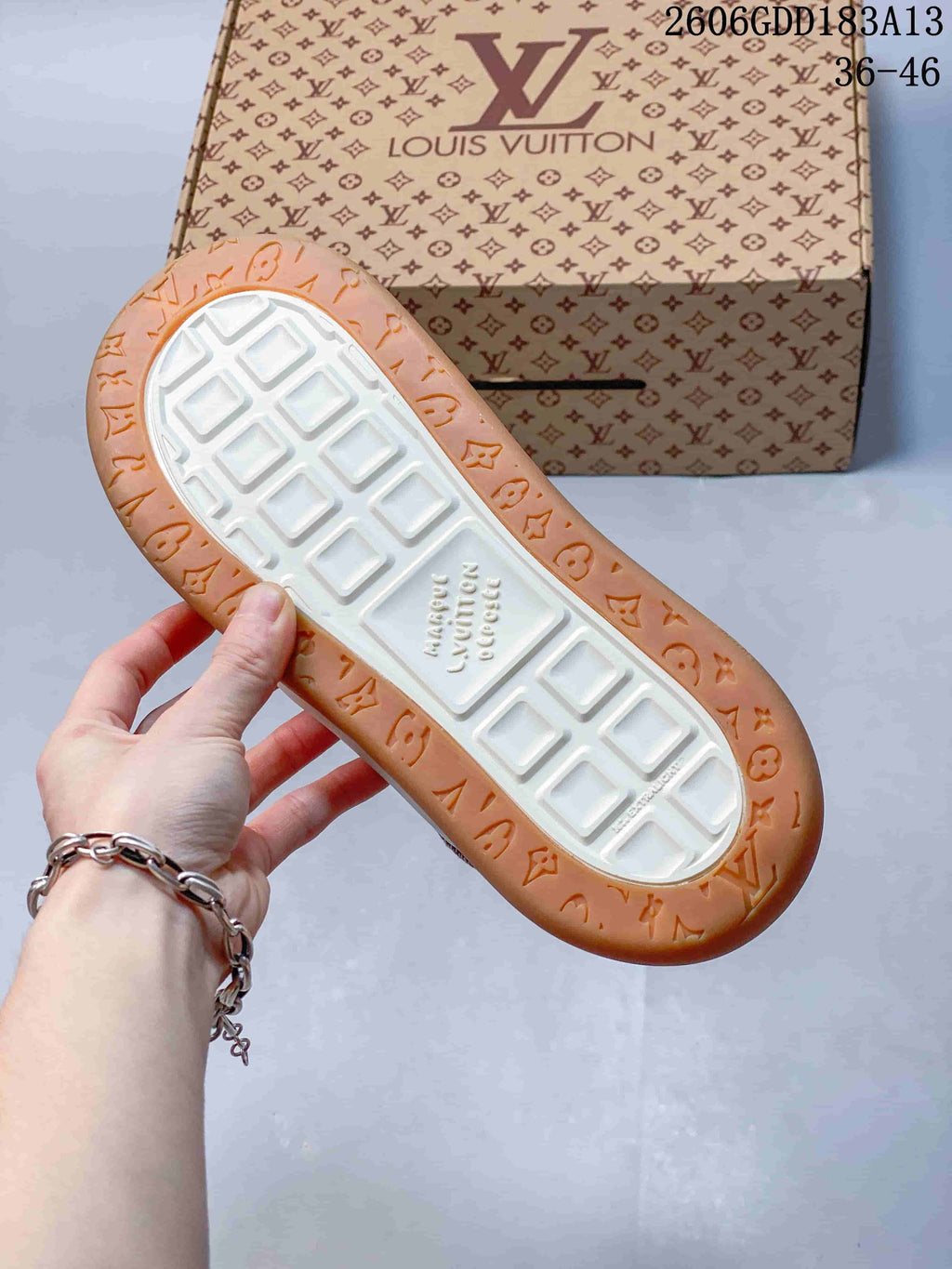 View of the sneaker outsole with white central tread and tan patterned border