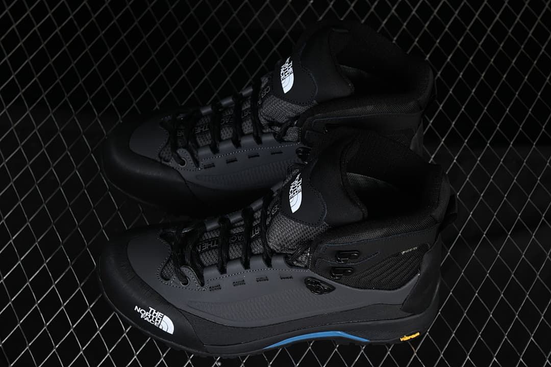 Pair of black and gray mid-height hiking boots with blue accents