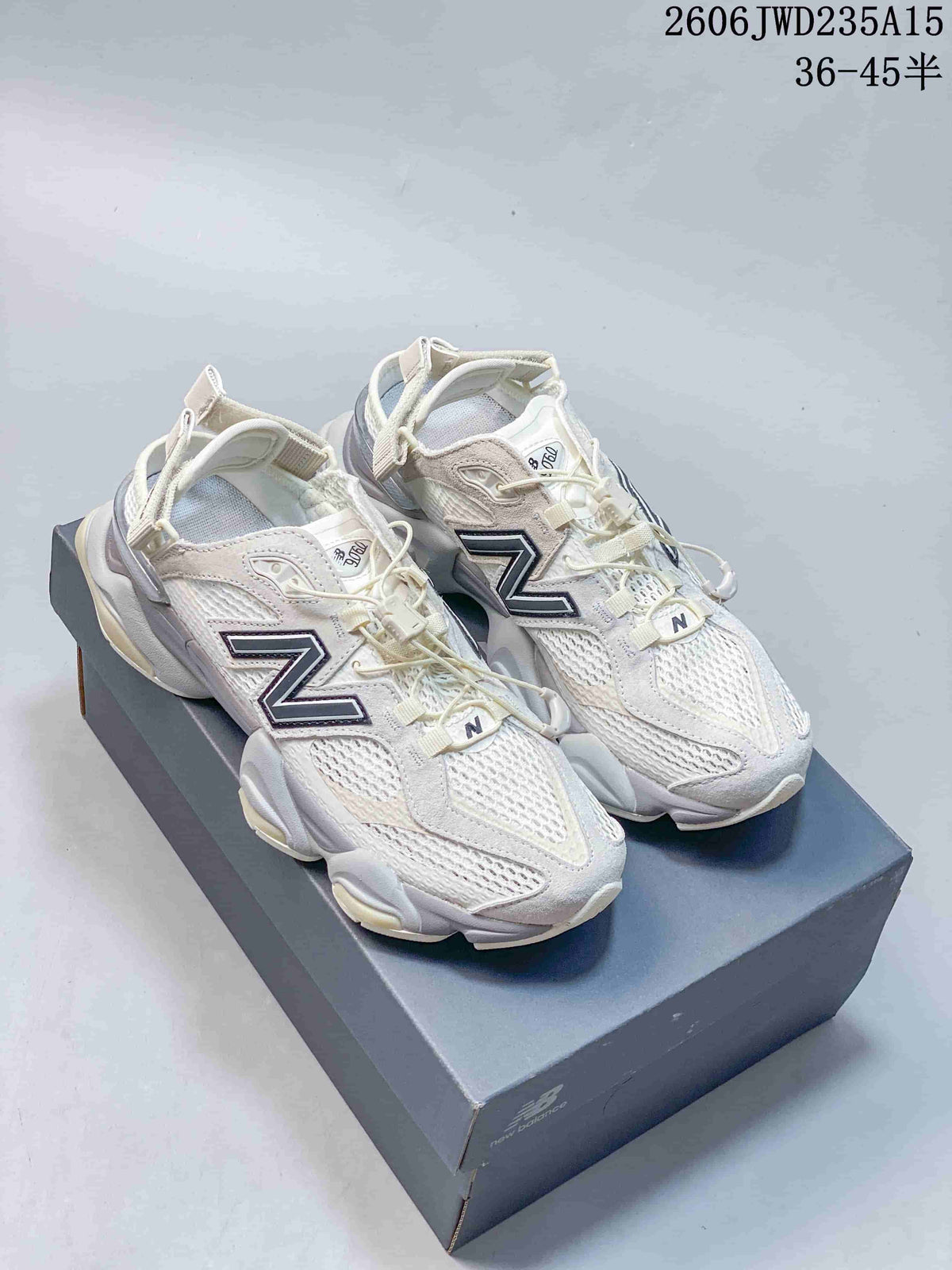Pair of white and gray New Balance 9060 sneakers on a shoebox