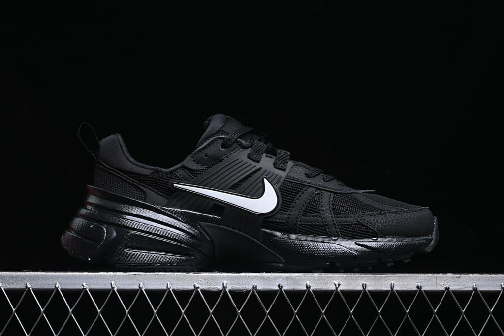 Side profile of a black Nike V2K Run shoe with a white Swoosh