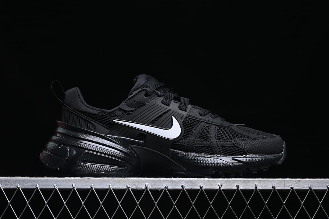 Side profile of a black Nike V2K Run shoe with a white Swoosh