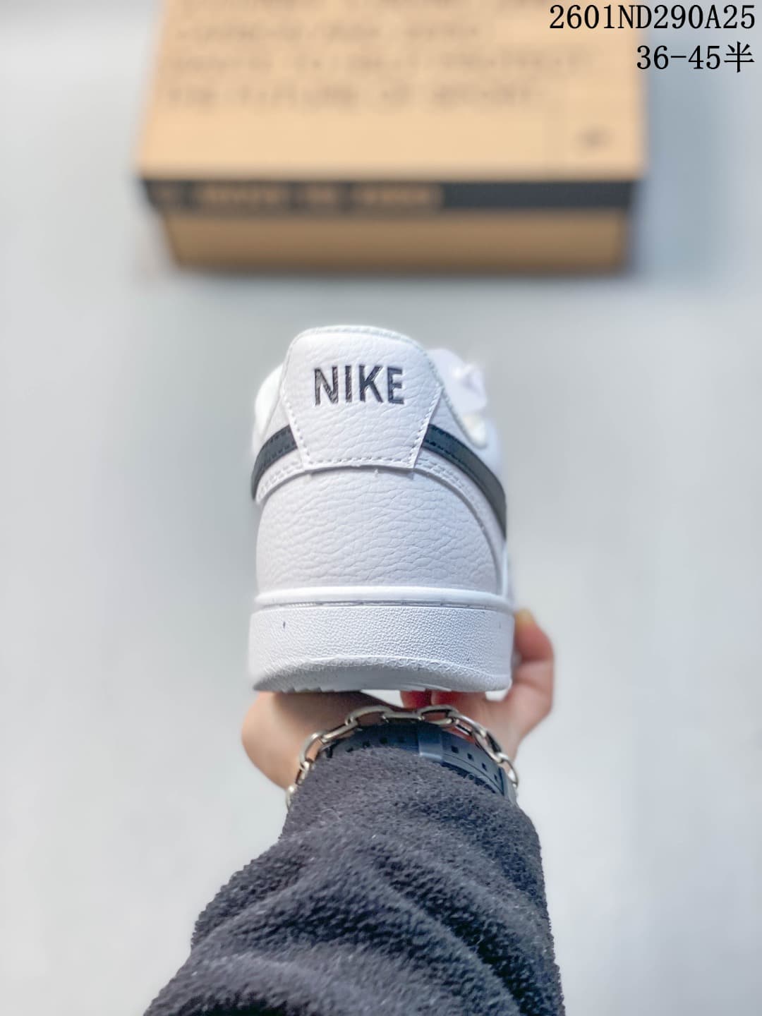 Rear view of a white Nike sneaker with a dark heel detail