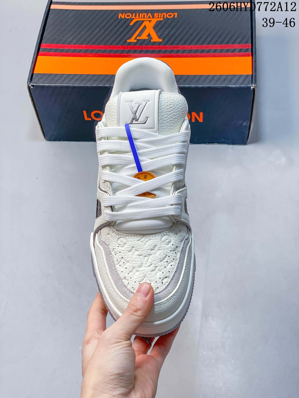 Front view of a white lace-up sneaker with patterned toe panels.