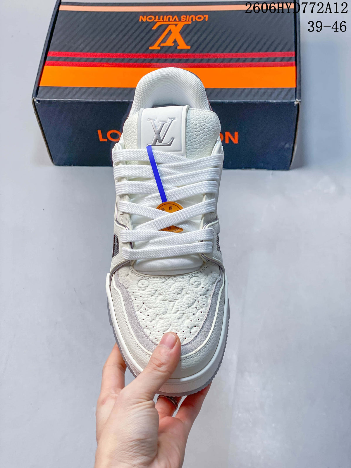 Front view of a white lace-up sneaker with patterned toe panels.