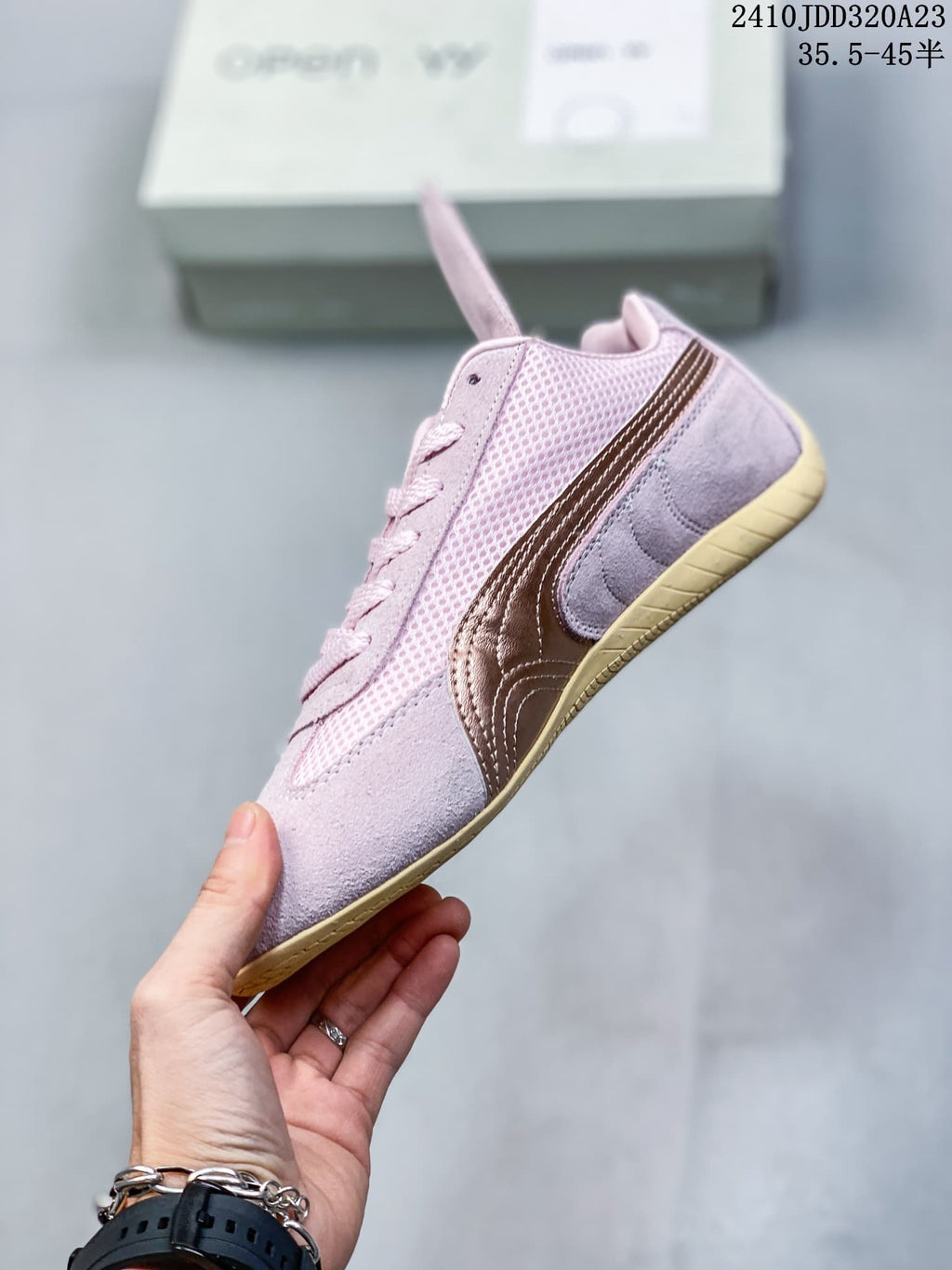 Side profile of the pink sneaker with mesh panels, bronze stripe, and gum-colored sole