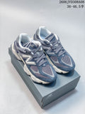 Pair of blue-grey New Balance 9060 sneakers shown on a shoebox