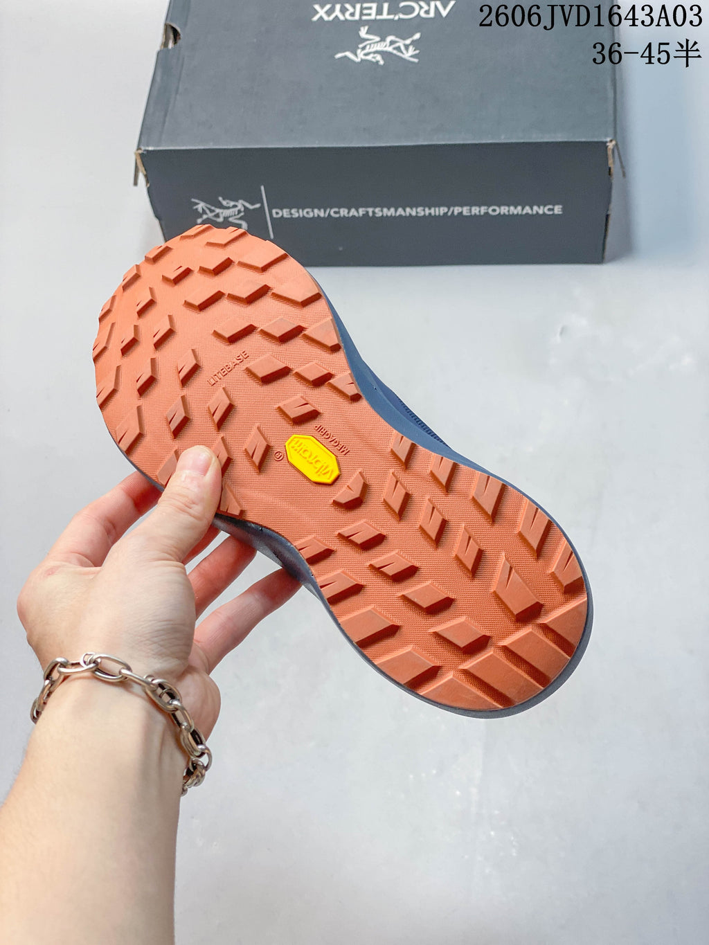 Close-up of the orange lugged outsole with Vibram marking