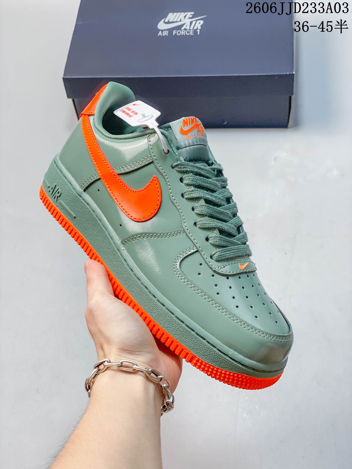 Angled side view of a green Air Force 1 ’07 sneaker with orange accents