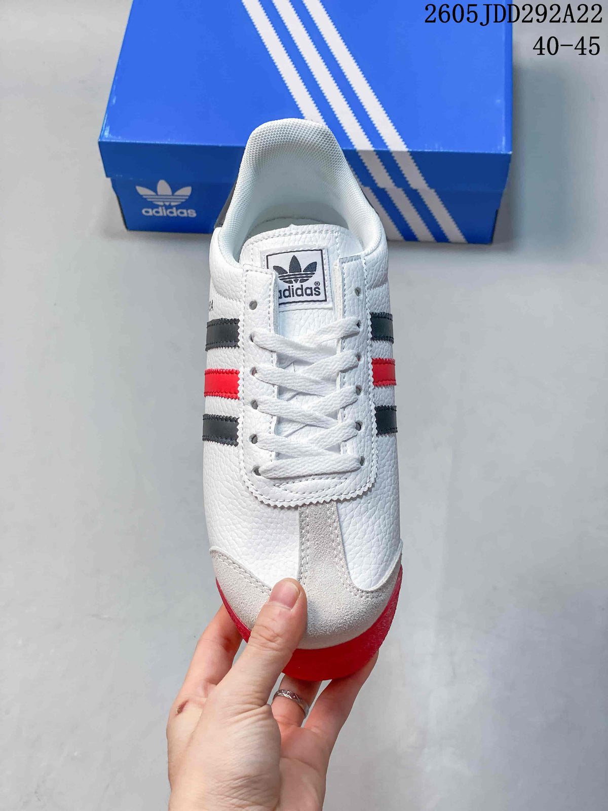 Front view of the white lace-up sneaker with light-colored toe overlays and contrasting stripes.
