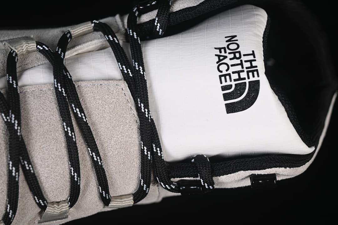 Close-up of tongue branding, laces, and light-colored upper