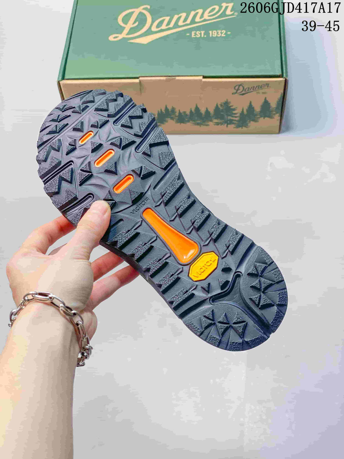 Close-up of the shoe's patterned tread outsole, with a Danner box in the background.