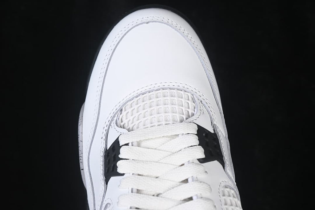 Top view of the white sneaker toe, mesh panel and black lace wings