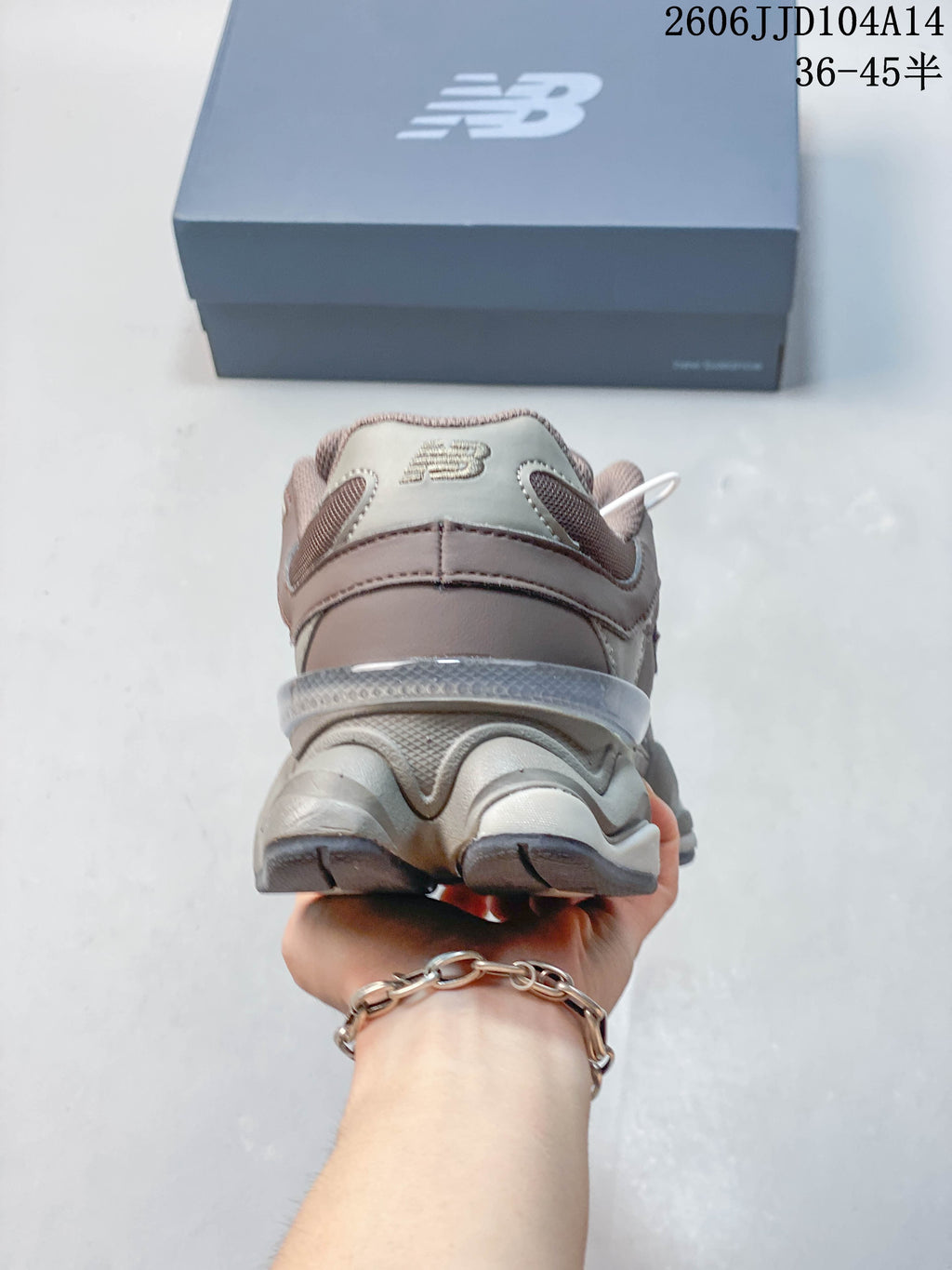 Rear view of a mauve and grey New Balance 9060 sneaker with a sculpted heel and sole.