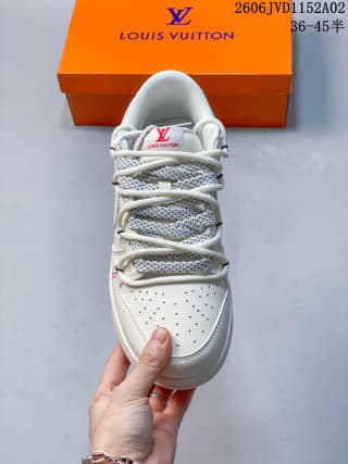 Top view of the white sneaker showing the perforated toe box, gray patterned laces, tongue branding, and padded collar.