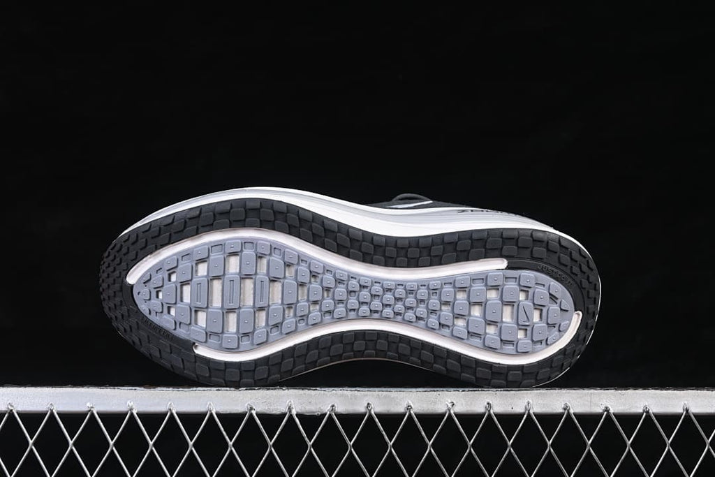 Underside of the Nike Vomero Plus shoe showing its patterned black and gray outsole.