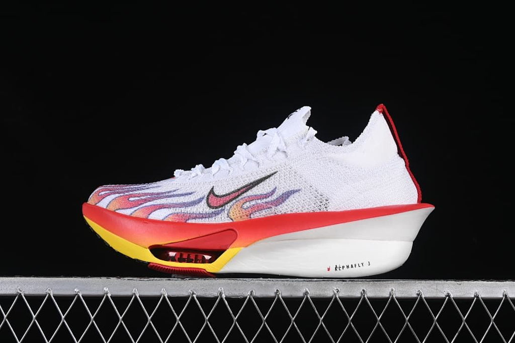 Side view of a white Nike running shoe with red, yellow, and multicolor flame-style graphics