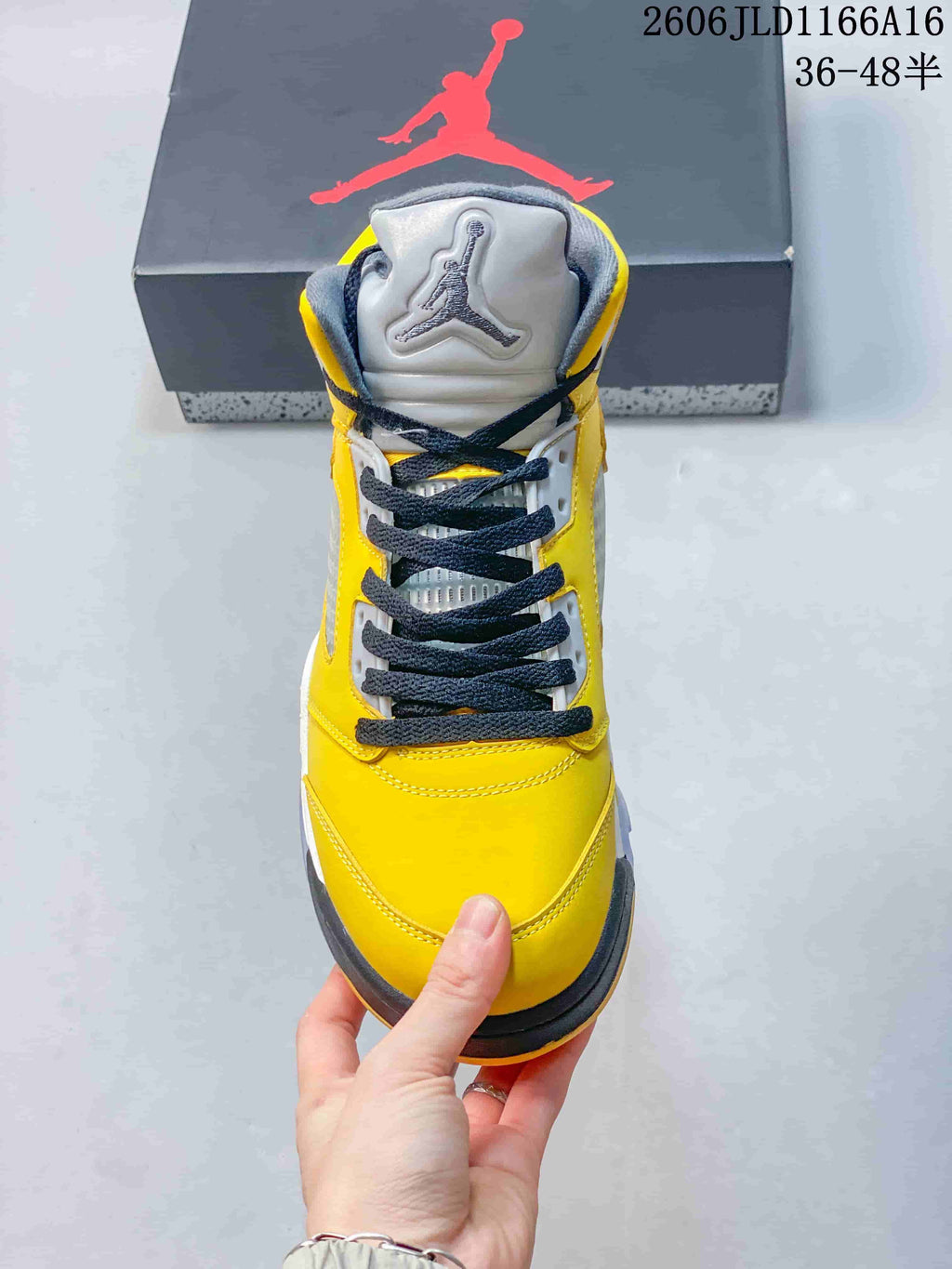 Front view of a yellow Air Jordan 5 Retro sneaker with dark laces