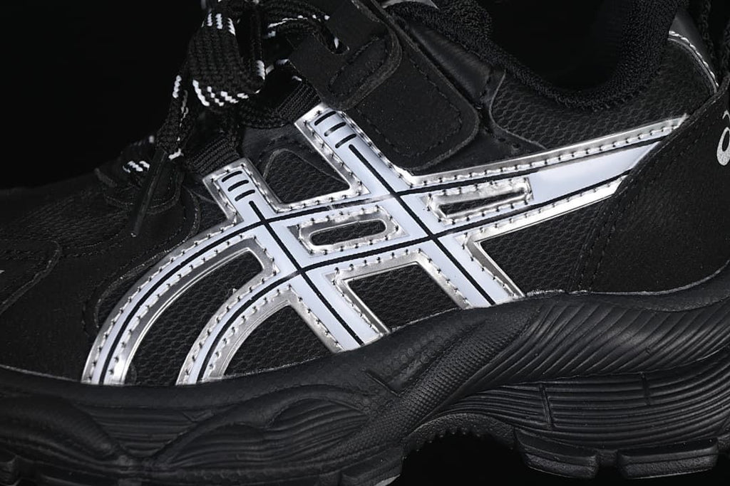 Close-up of the silver side accents, black upper, and textured outsole.