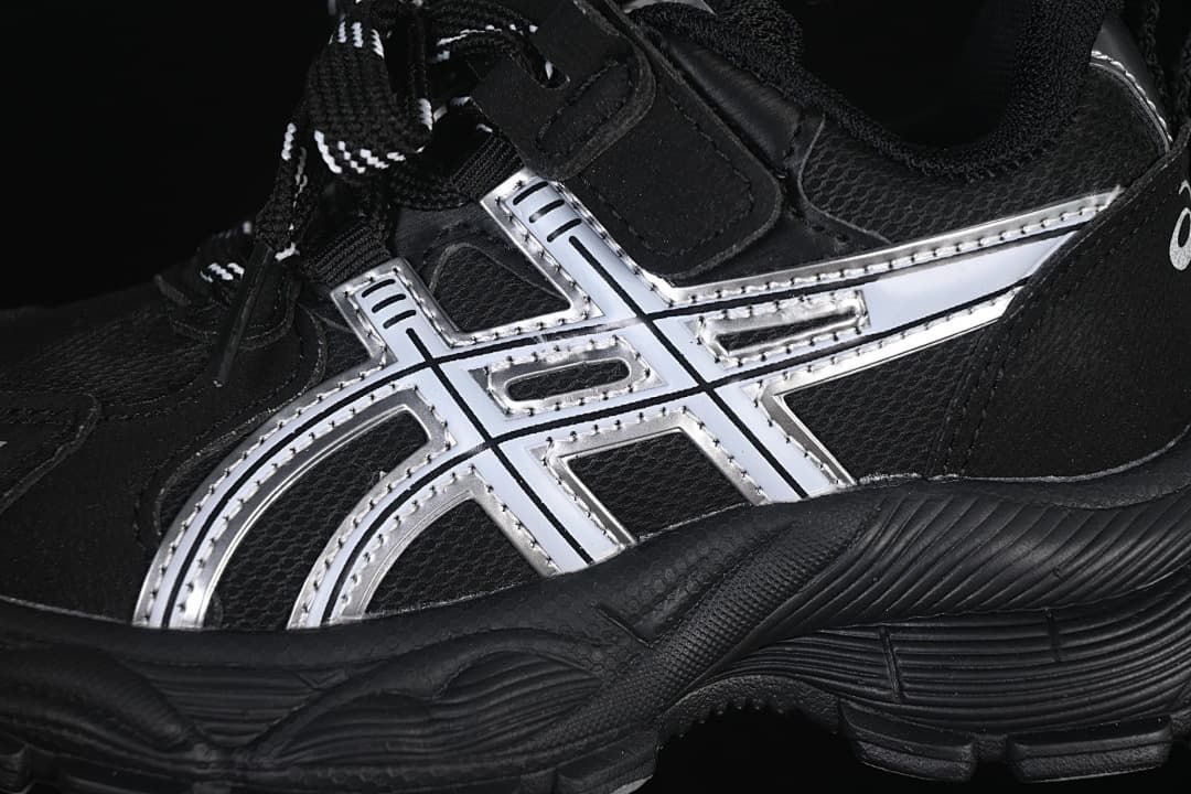 Close-up of the silver side accents, black upper, and textured outsole.