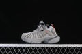 Side view of cement grey kids’ adidas Adistar sneakers against a dark background.