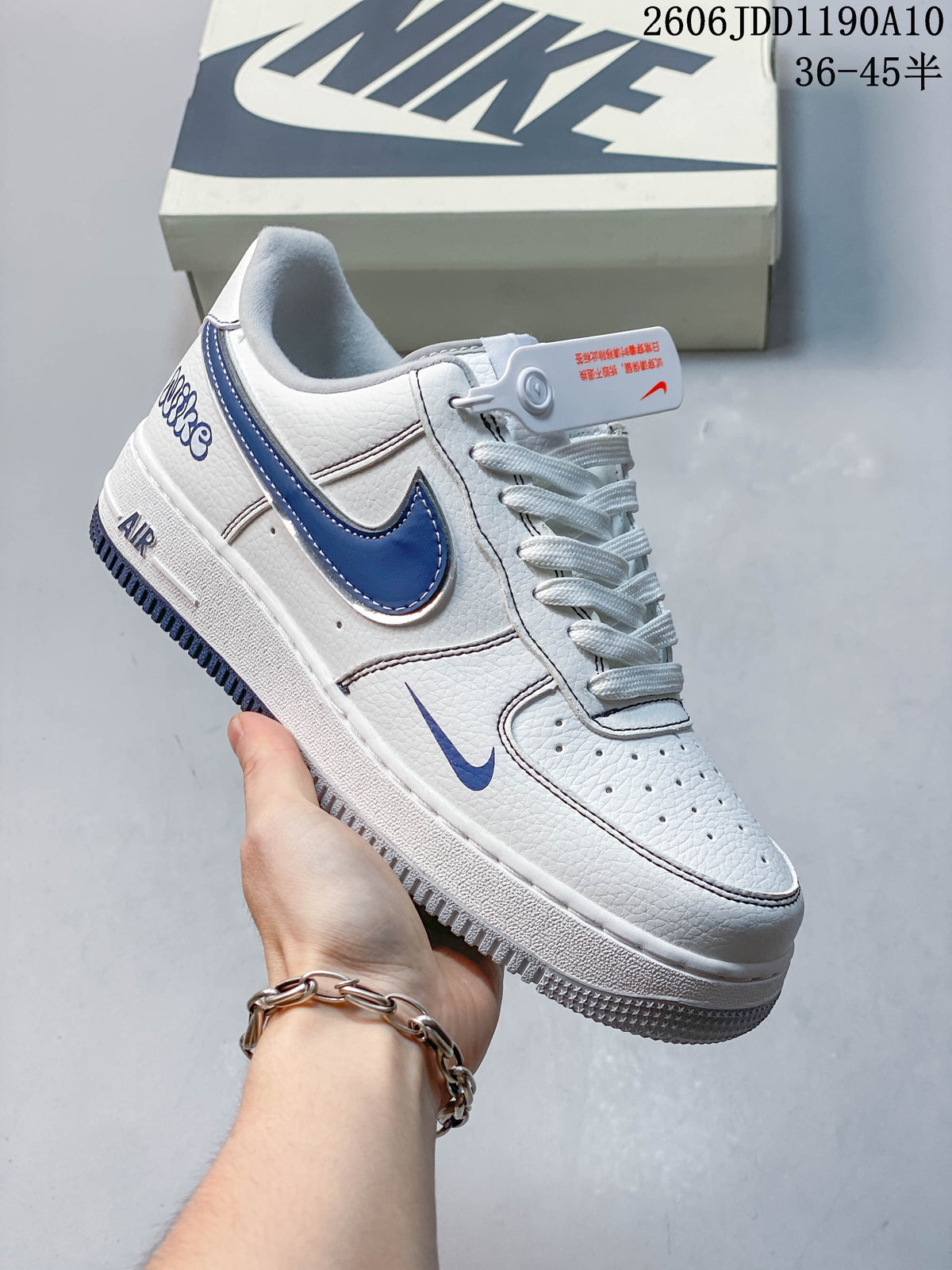 Angled side view of the white sneaker with blue Swoosh accents