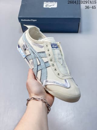 Angled front-side view of the cream and blue low-top sneaker with reinforced toe detailing.
