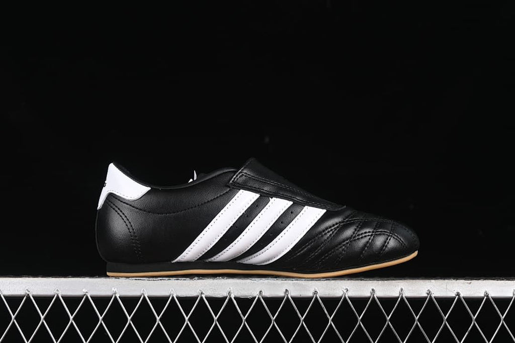 Side profile highlighting the black upper, white stripes, and low-cut shape.