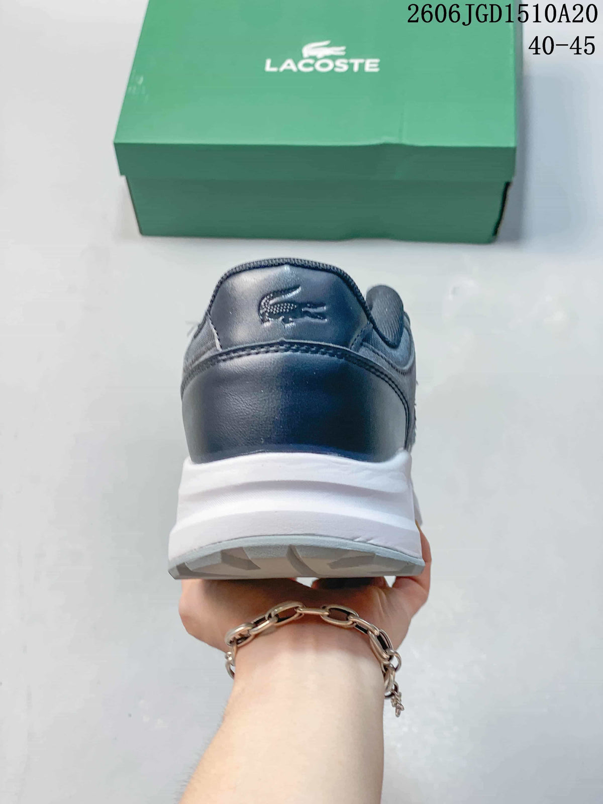 Rear view showing the heel and white midsole of a grey and navy sneaker.