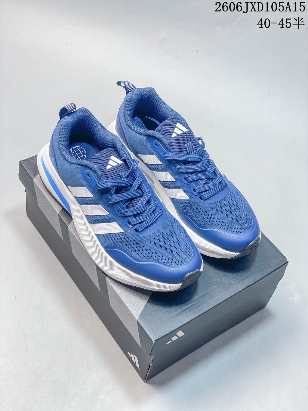 Blue Adidas Ultrabounce shoes with white side stripes shown on a shoebox