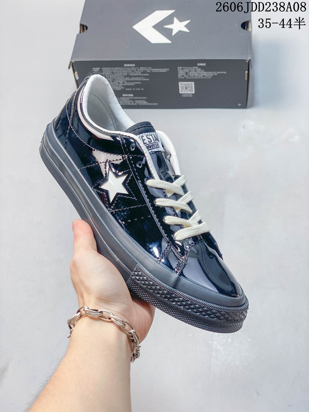 Angled side view of a glossy navy Converse One Star sneaker with a white star accent
